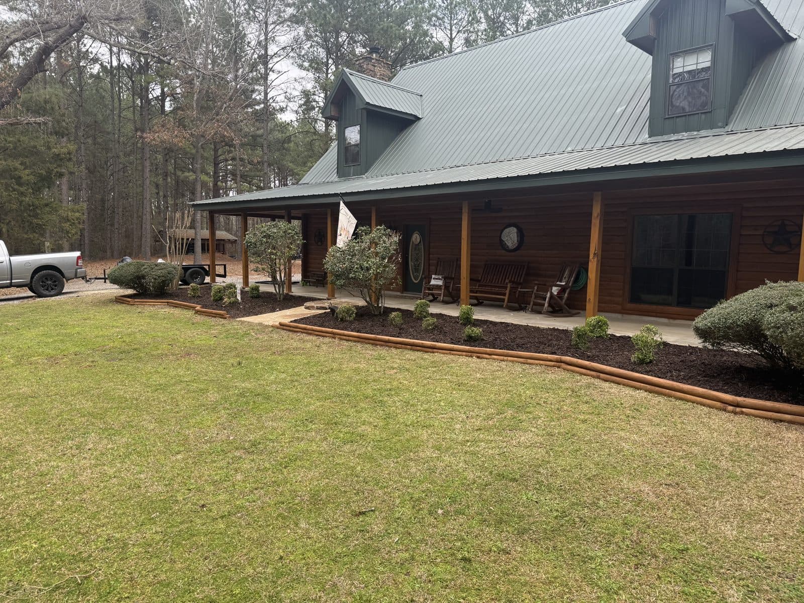 After - clean yard with fresh mulch, log edging, and trimmed landscaping